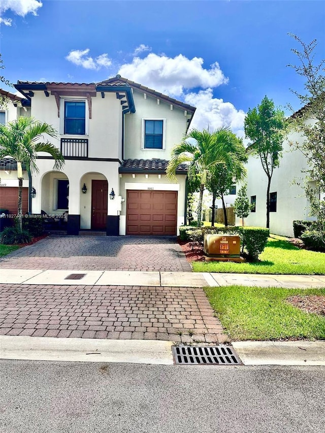 8861 NW 102nd Pl, Doral, FL 33178 - mediterranean / spanish-style home featuring decorative driveway, stucco siding, an attached garage, and a tiled roof