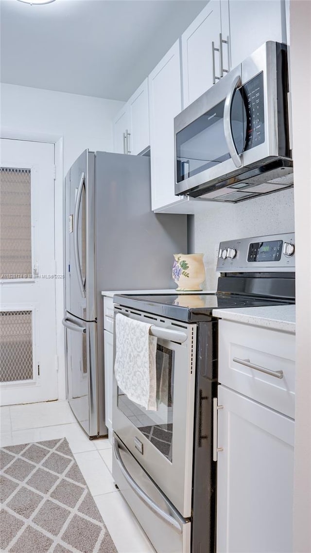 16801 NE 13th Ave Unit 202, Miami, FL 33162 - kitchen with appliances with stainless steel finishes, white cabinets, light tile patterned floors, and light countertops