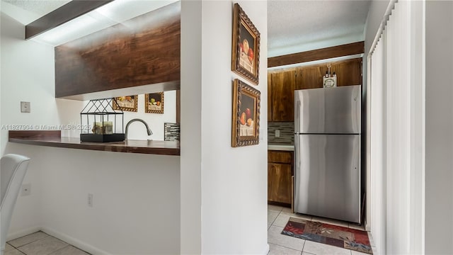 9109 SW 20th St, Davie, FL 33324 - kitchen with freestanding refrigerator, light tile patterned flooring, and brown cabinetry
