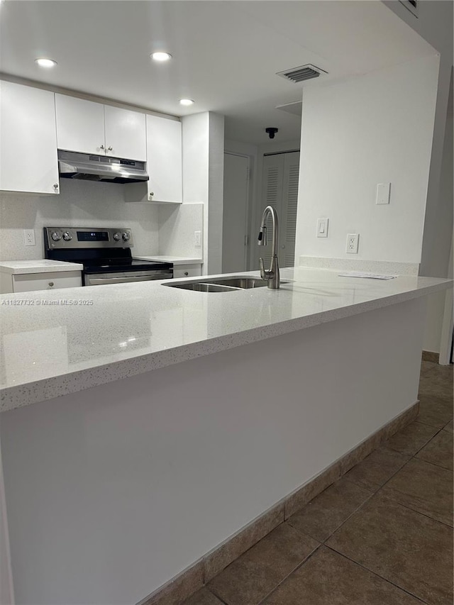 8100 Geneva Ct Unit 142, Doral, FL 33166 - kitchen featuring under cabinet range hood, stainless steel range with electric stovetop, white cabinets, light stone counters, and dark tile patterned flooring