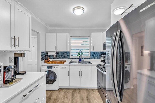 805 W Oakland Park Blvd Unit E14, Oakland Park, FL 33311 - kitchen featuring washer / dryer, stainless steel appliances, light wood-type flooring, ornamental molding, and tasteful backsplash