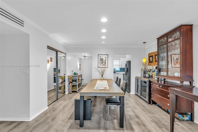 805 W Oakland Park Blvd Unit E14, Oakland Park, FL 33311 - dining area featuring light wood-style floors, a dry bar, crown molding, recessed lighting, and wine cooler