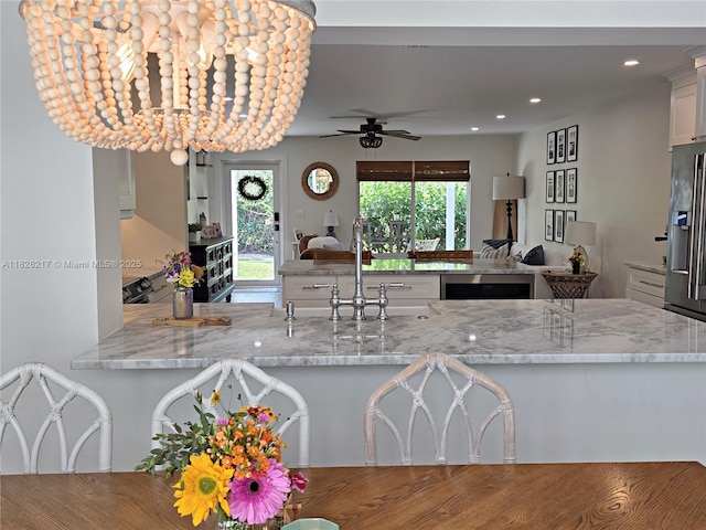 8994 SE Colony St, Hobe Sound, FL 33455 - kitchen with ceiling fan, open floor plan, light stone counters, recessed lighting, and wine cooler