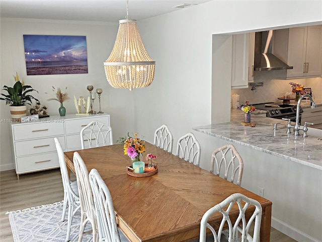 8994 SE Colony St, Hobe Sound, FL 33455 - dining area featuring light wood-style floors, a chandelier, and crown molding