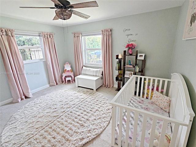 8994 SE Colony St, Hobe Sound, FL 33455 - carpeted bedroom featuring multiple windows, a nursery area, and a ceiling fan