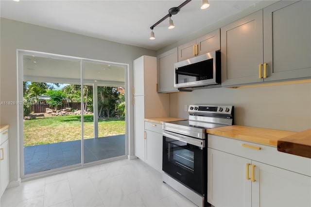 246 NE 13th St, Delray Beach, FL 33444 - kitchen with stainless steel appliances, light marble finish floors, and wood counters