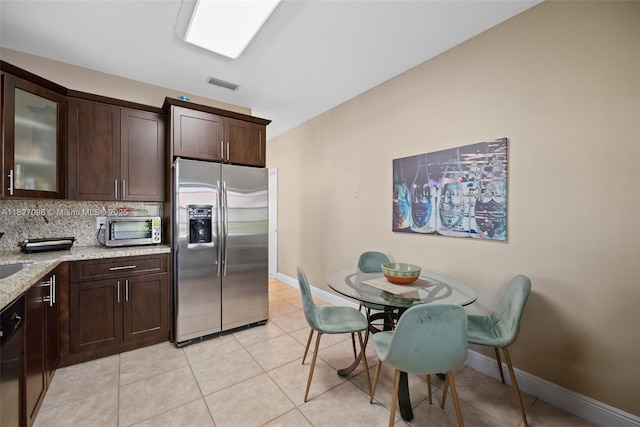 1115 SW 180th Ter, Pembroke Pines, FL 33029 - kitchen featuring appliances with stainless steel finishes, dark brown cabinets, light stone counters, light tile patterned flooring, and decorative backsplash