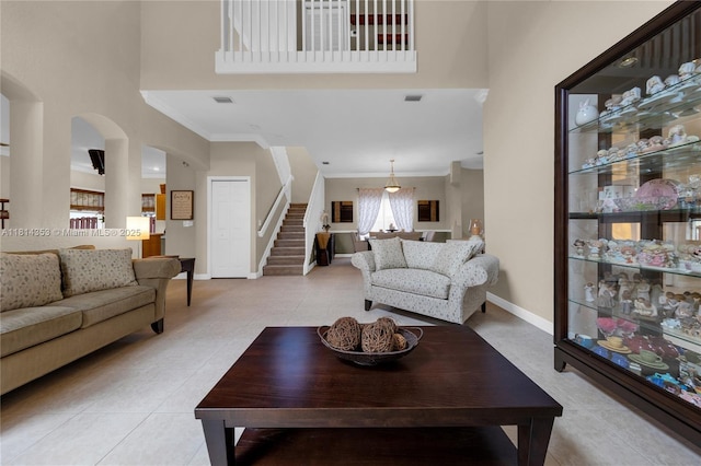 14141 SW 54th St, Miramar, FL 33027 - living room featuring light tile patterned floors, a towering ceiling, ornamental molding, stairway, and arched walkways