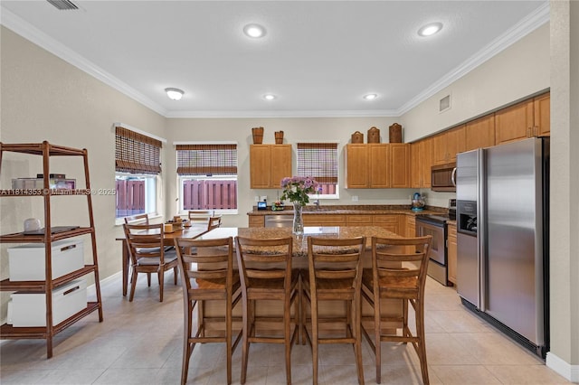 14141 SW 54th St, Miramar, FL 33027 - kitchen with stainless steel appliances, light tile patterned flooring, crown molding, a kitchen island, and a breakfast bar