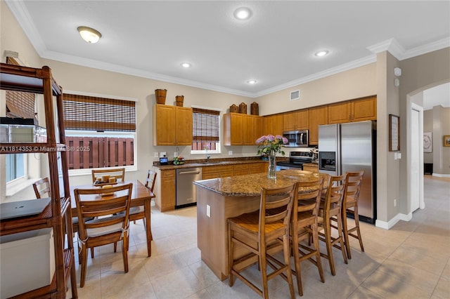 14141 SW 54th St, Miramar, FL 33027 - kitchen featuring appliances with stainless steel finishes, arched walkways, a kitchen island, light tile patterned flooring, and ornamental molding