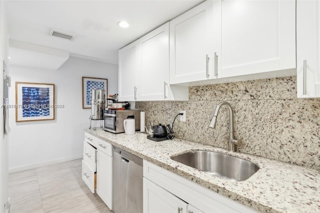 2401 Collins Ave Unit 1011, Miami Beach, FL 33140 - kitchen featuring appliances with stainless steel finishes, white cabinets, backsplash, light stone counters, and recessed lighting