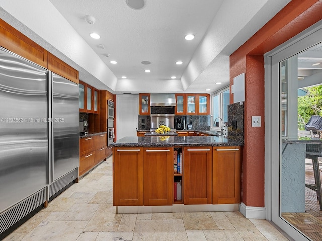 6005 SW 135th Ter, Pinecrest, FL 33156 - kitchen featuring backsplash, glass insert cabinets, wall chimney exhaust hood, recessed lighting, and a textured wall