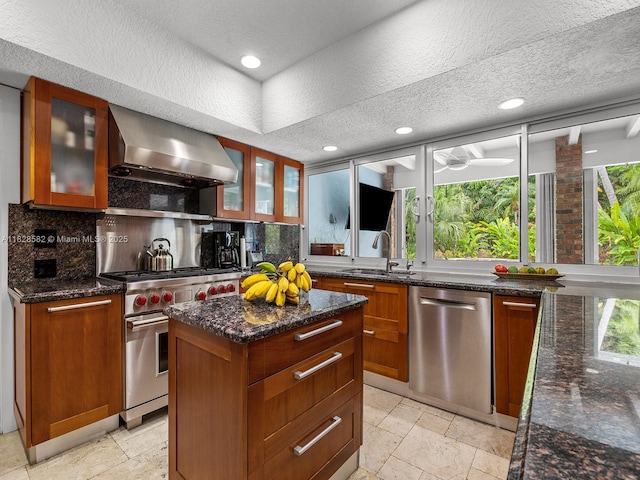 6005 SW 135th Ter, Pinecrest, FL 33156 - kitchen featuring stainless steel appliances, wall chimney range hood, healthy amount of natural light, stone tile flooring, and a textured ceiling