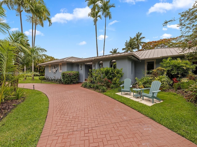 6005 SW 135th Ter, Pinecrest, FL 33156 - view of front facade with stucco siding, curved driveway, a standing seam roof, and a front yard