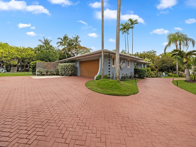 6005 SW 135th Ter, Pinecrest, FL 33156 - mid-century home with curved driveway, an attached garage, and stucco siding