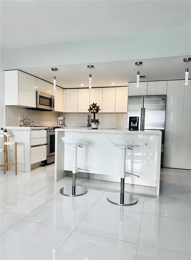 19390 Collins Ave Unit 911, Sunny Isles Beach, FL 33160 - kitchen with stainless steel appliances, modern cabinets, white cabinetry, and light countertops