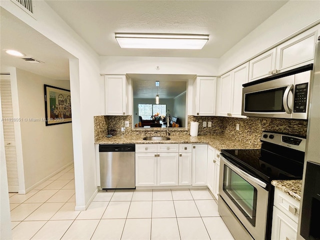 6080 Huntwick Ter Unit 305, Delray Beach, FL 33484 - kitchen with appliances with stainless steel finishes, backsplash, light tile patterned flooring, white cabinetry, and light stone counters