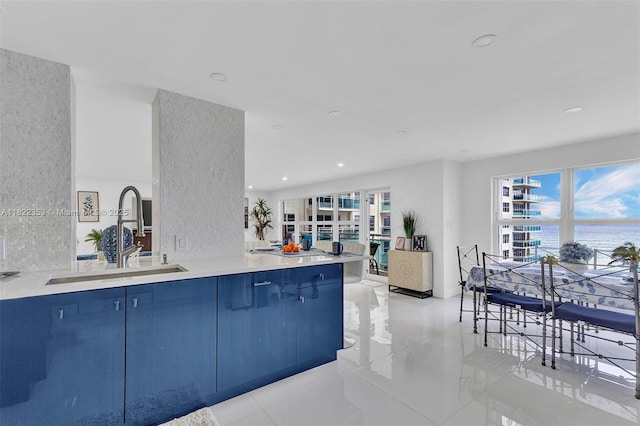 3900 Galt Ocean Dr Unit 506, Fort Lauderdale, FL 33308 - kitchen with blue cabinets, light tile patterned flooring, a water view, healthy amount of natural light, and recessed lighting