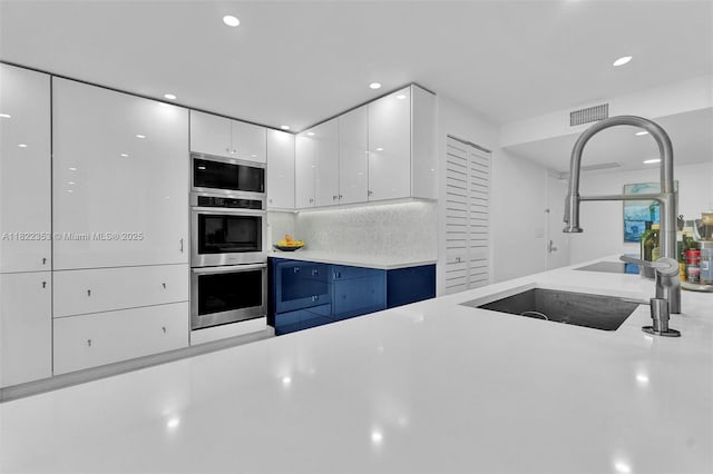 3900 Galt Ocean Dr Unit 506, Fort Lauderdale, FL 33308 - kitchen with stainless steel appliances, white cabinetry, light countertops, recessed lighting, and decorative backsplash
