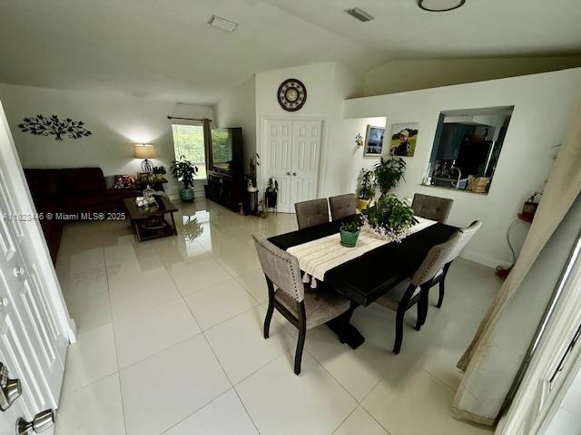 767 SE 22nd Dr, Homestead, FL 33033 - dining space with lofted ceiling and light tile patterned floors