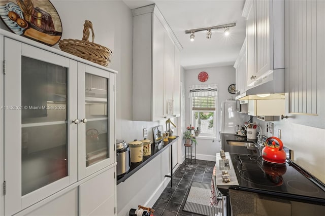 405 SW 29th Ct Unit 4A, Miami, FL 33135 - kitchen with under cabinet range hood, white cabinets, electric range oven, dark tile patterned floors, and rail lighting