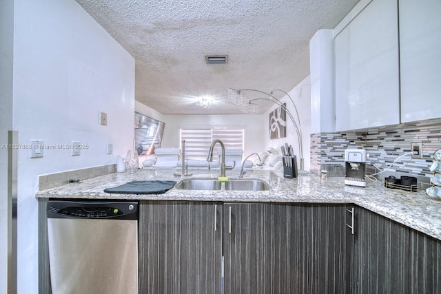 10000 SW 147th Ct, Miami, FL 33196 - kitchen with stainless steel dishwasher, a textured ceiling, backsplash, light stone countertops, and a peninsula