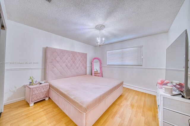 10000 SW 147th Ct, Miami, FL 33196 - bedroom with light wood-type flooring, a chandelier, and a textured ceiling