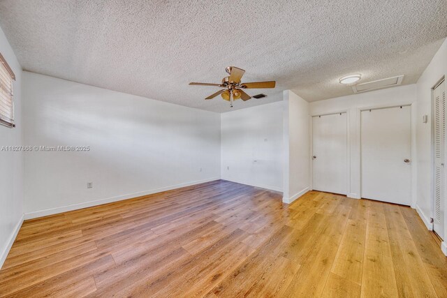 10000 SW 147th Ct, Miami, FL 33196 - unfurnished bedroom with attic access, light wood-type flooring, multiple closets, a textured ceiling, and ceiling fan