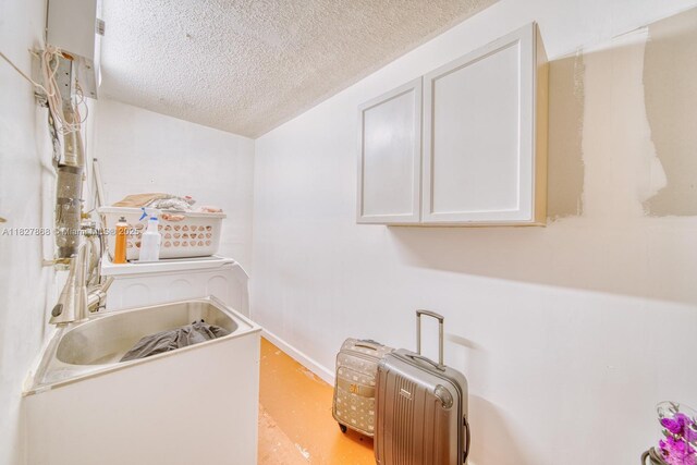 10000 SW 147th Ct, Miami, FL 33196 - washroom featuring a textured ceiling and cabinet space