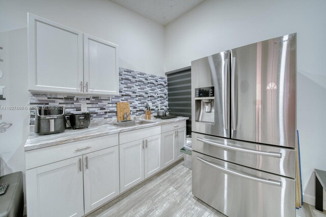 10000 SW 147th Ct, Miami, FL 33196 - kitchen featuring stainless steel fridge, backsplash, white cabinets, and light wood-style flooring