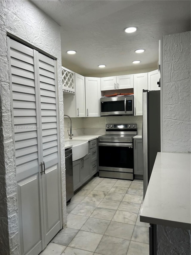 38 Northampton B 38, West Palm Beach, FL 33417 - kitchen featuring appliances with stainless steel finishes, gray cabinets, light countertops, recessed lighting, and white cabinetry