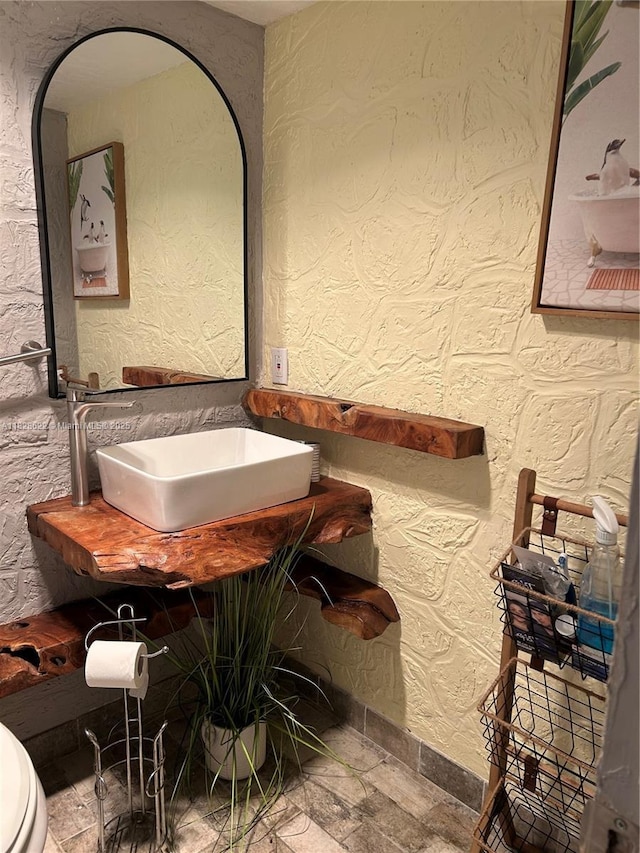 38 Northampton B 38, West Palm Beach, FL 33417 - half bathroom featuring a textured wall and stone finish flooring
