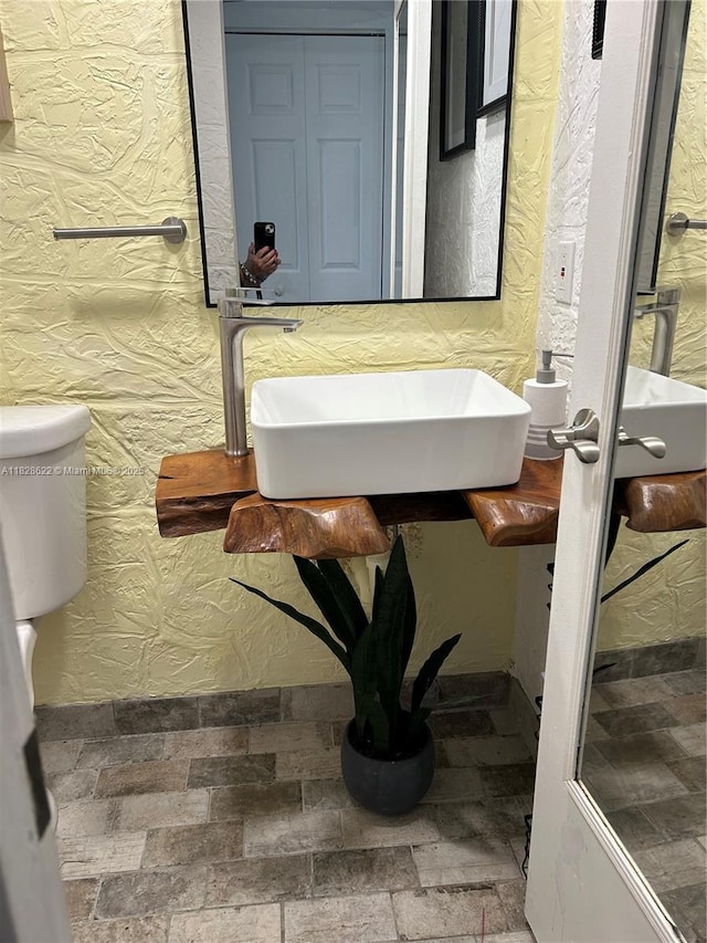 38 Northampton B 38, West Palm Beach, FL 33417 - bathroom featuring toilet and stone finish floors