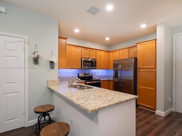 5656 NW 58th Ln, Tamarac, FL 33319 - kitchen with appliances with stainless steel finishes, dark wood finished floors, a peninsula, light stone countertops, and recessed lighting