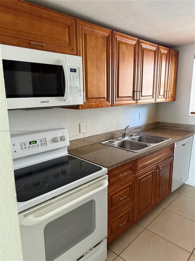 1142 99th St Unit 23, Bay Harbor Islands, FL 33154 - kitchen with white appliances, light tile patterned floors, brown cabinetry, a textured ceiling, and dark countertops