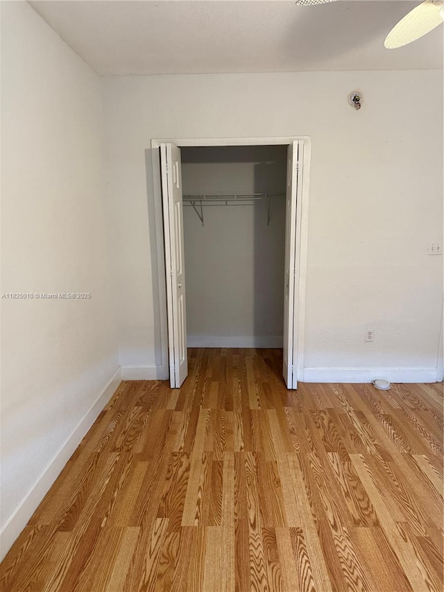 1142 99th St Unit 23, Bay Harbor Islands, FL 33154 - unfurnished bedroom featuring light wood-style floors and a closet
