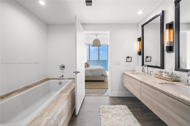 2900 NE 7th Ave Unit 2303, Miami, FL 33137 - bathroom featuring double vanity, a garden tub, wood finished floors, connected bathroom, and recessed lighting