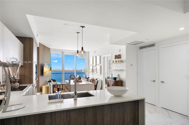 2900 NE 7th Ave Unit 2303, Miami, FL 33137 - kitchen with light marble finish floors, hanging light fixtures, light countertops, and a peninsula