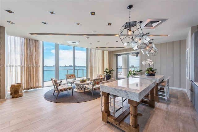 2900 NE 7th Ave Unit 2303, Miami, FL 33137 - dining room featuring wallpapered walls, a water view, light wood-style flooring, and a wall of windows