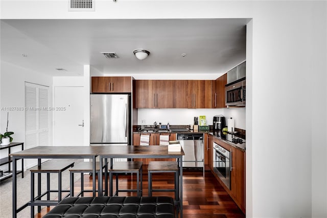 300 S Biscayne Blvd Unit T-1403, Miami, FL 33131 - kitchen with stainless steel appliances, dark countertops, brown cabinets, and modern cabinets