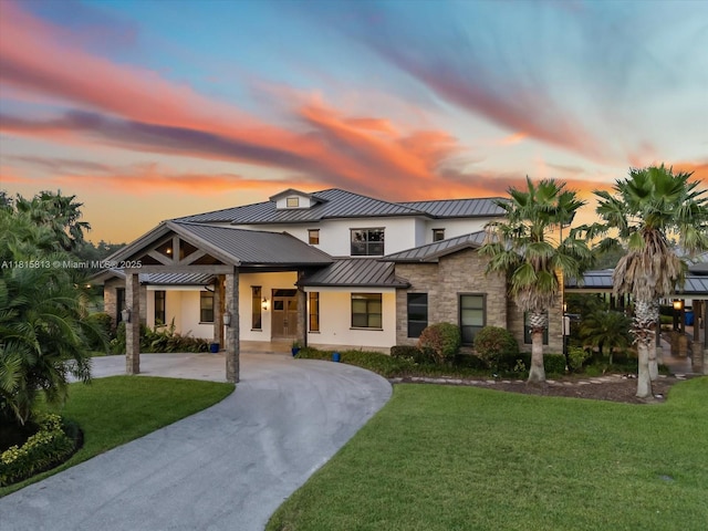 16675 C 24 Canal Rd, Port St Lucie, FL 34987 - modern farmhouse style home with a standing seam roof, stone siding, curved driveway, and a front lawn