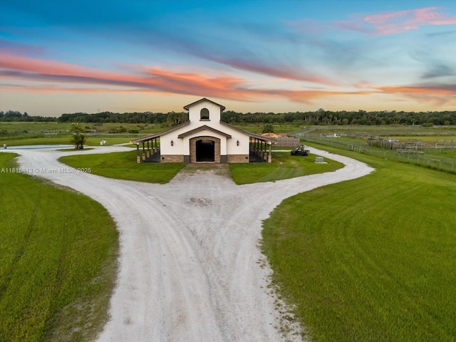 16675 C 24 Canal Rd, Port St Lucie, FL 34987 - view of front facade with a barn, driveway, an outdoor structure, a view of countryside, and stucco siding