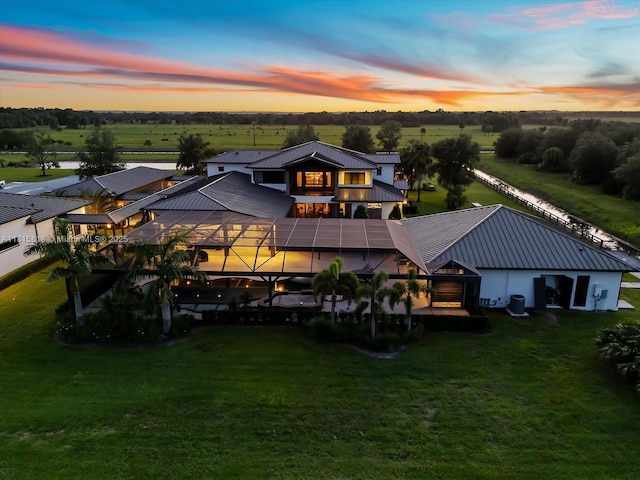 16675 C 24 Canal Rd, Port St Lucie, FL 34987 - back of house at dusk with a metal roof and a yard