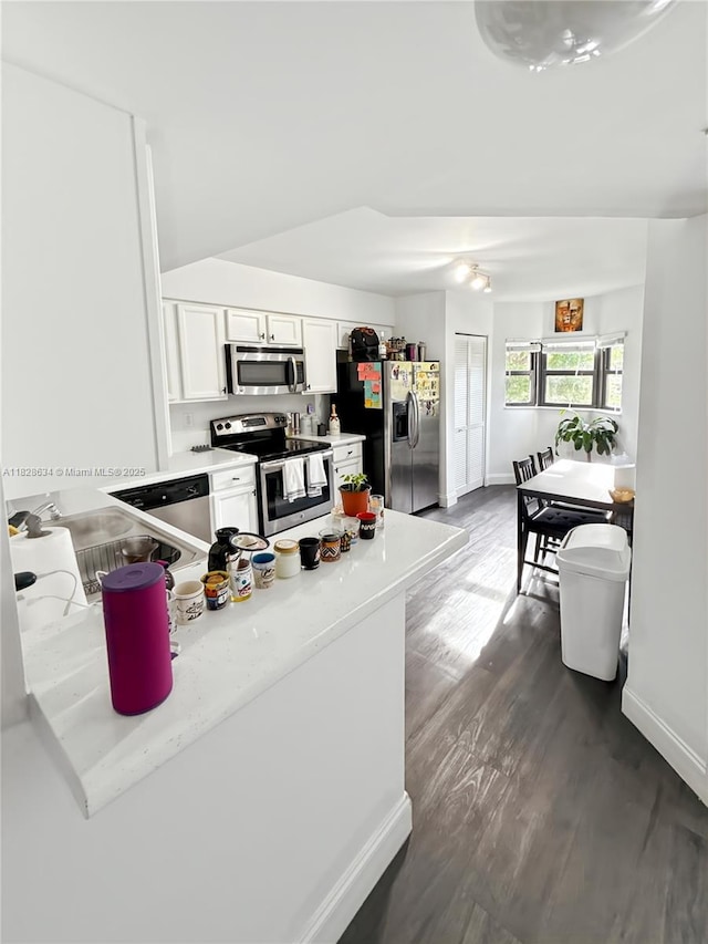 22551 SW 88th Pl Unit 205, Cutler Bay, FL 33190 - kitchen featuring stainless steel appliances, white cabinetry, dark wood finished floors, light countertops, and a peninsula