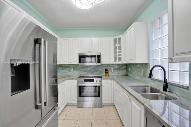 15827 NW 4th Ct, Pembroke Pines, FL 33028 - kitchen with appliances with stainless steel finishes, light stone countertops, white cabinets, backsplash, and a textured ceiling