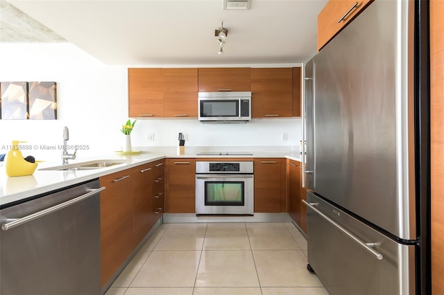 3250 NE 1st Ave Unit 911, Miami, FL 33137 - kitchen featuring appliances with stainless steel finishes, brown cabinets, light countertops, and light tile patterned floors