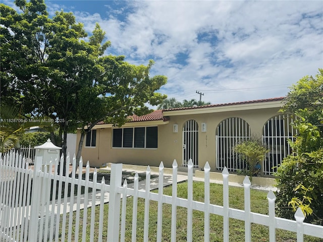 3915 NW 4th Ter, Miami, FL 33126 - view of front of home featuring stucco siding, a tiled roof, and a fenced front yard