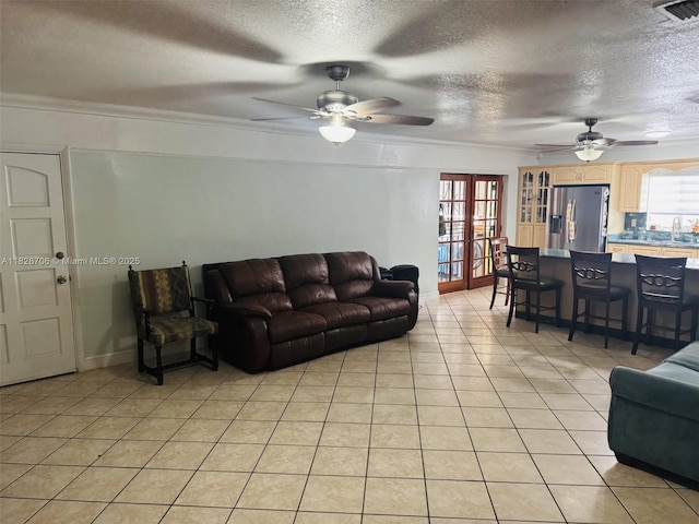 3915 NW 4th Ter, Miami, FL 33126 - living room featuring ceiling fan, crown molding, a textured ceiling, light tile patterned floors, and french doors