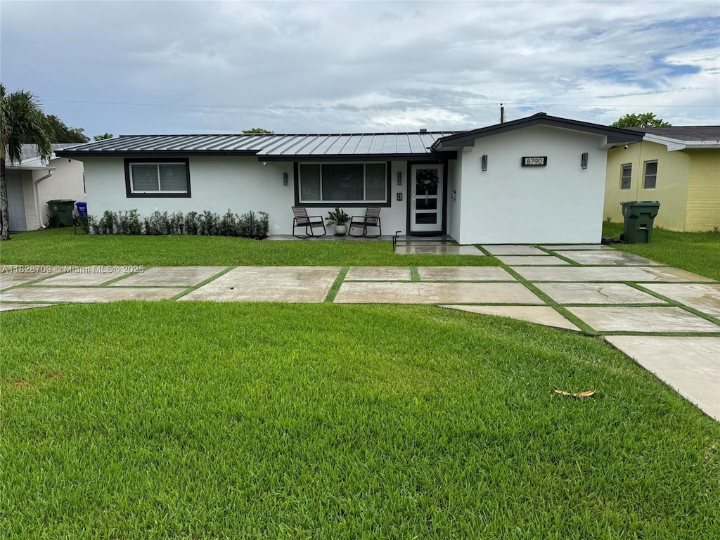 8790 NW 15th Ct, Pembroke Pines, FL 33024 - ranch-style home with stucco siding, a front yard, a standing seam roof, and a metal roof