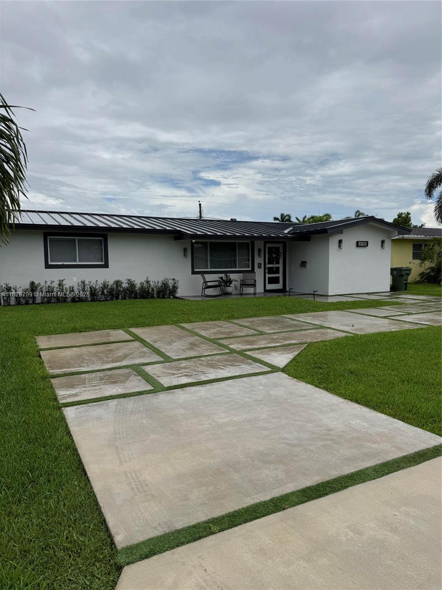 8790 NW 15th Ct, Pembroke Pines, FL 33024 - single story home with stucco siding, a front lawn, a standing seam roof, and a metal roof